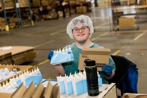 Employee smiles and poses with a PetAg product.